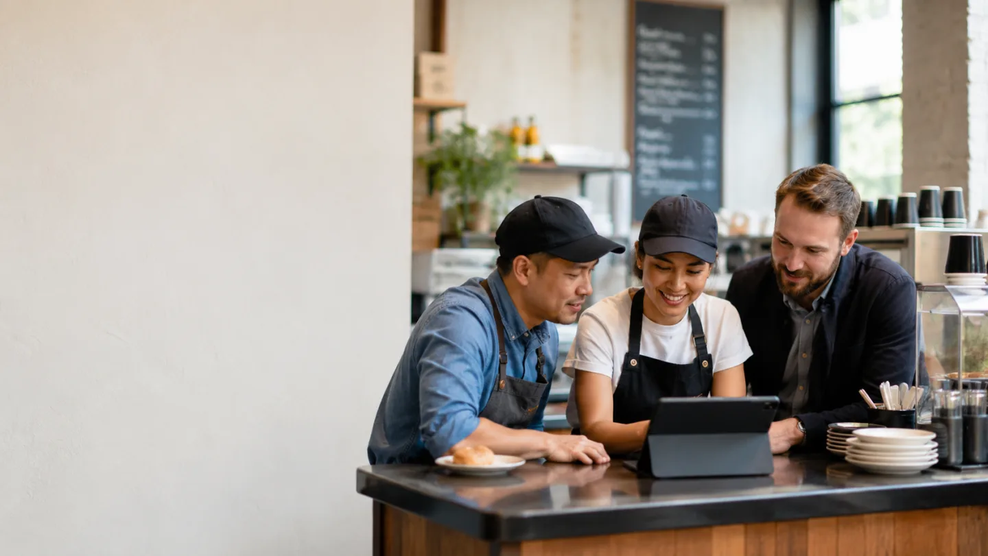 A restaurant team reviewing their business tools together on a tablet